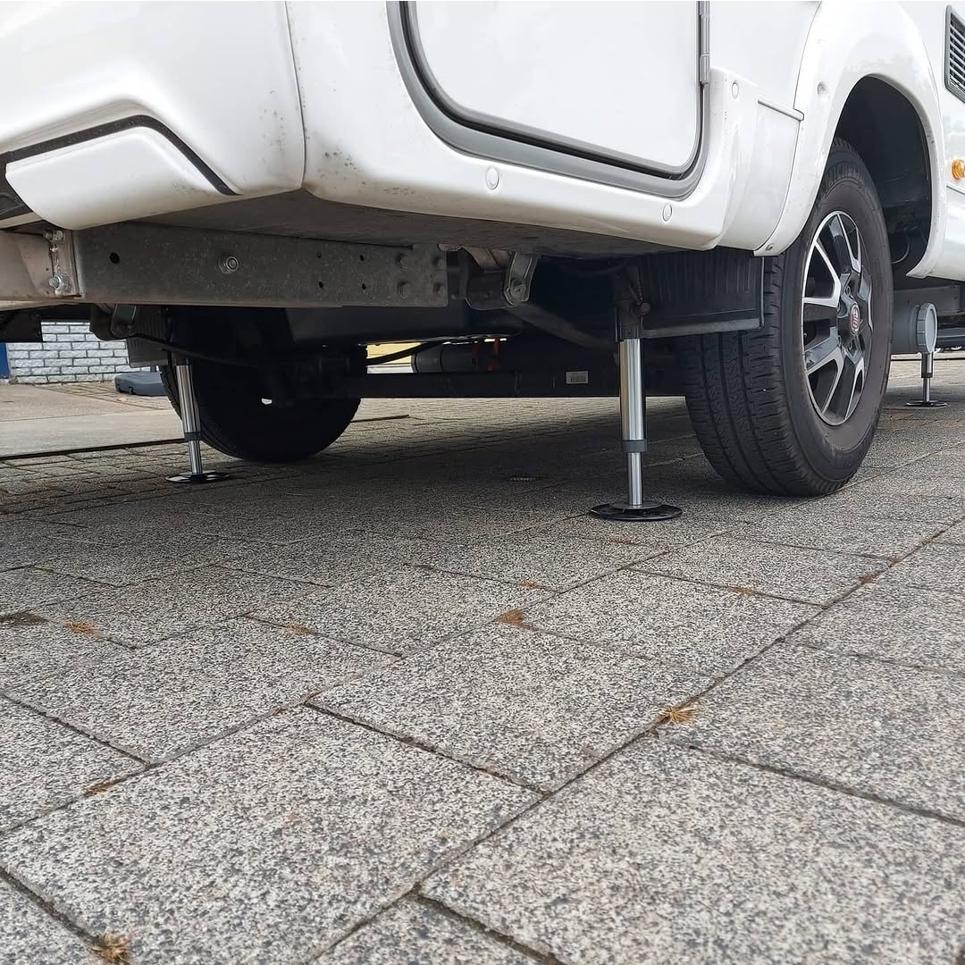 Uitgeklapte hydraulische cilinder van het Amplo Level System onder een camper
